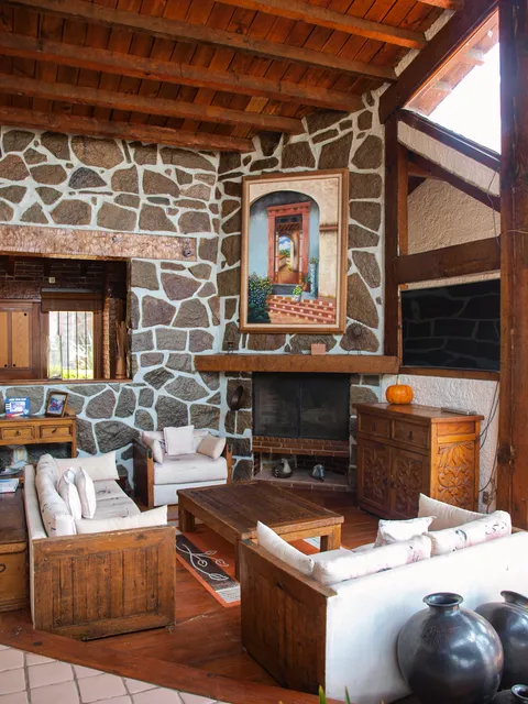 Sala con chimenea de piedra de una propiedad representada por MEVE